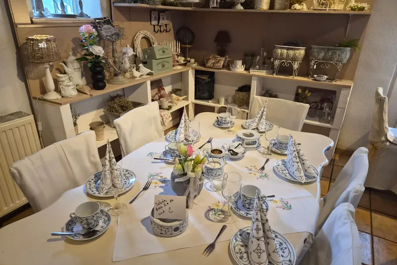 Für eine Gesellschaft eingedeckte Tafel mit weißen Stuhlhussen und blauem Geschirr